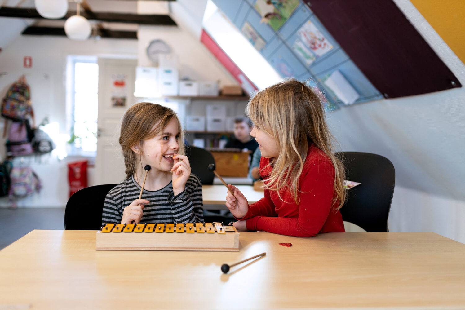 To piger spiller xylofon i musikundervisningen på Vanløse Friskole – en tryg friskole med plads til kreativitet.